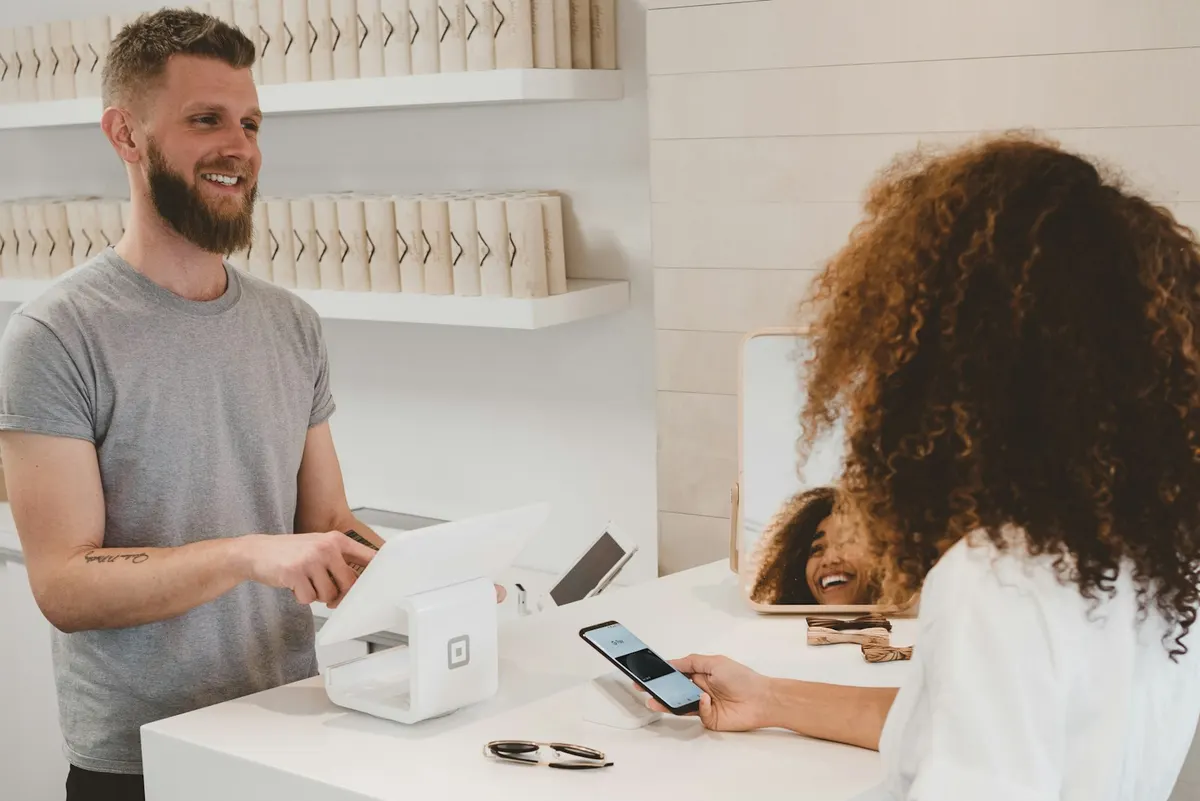 Comerciante atendiendo a un cliente en su tienda local